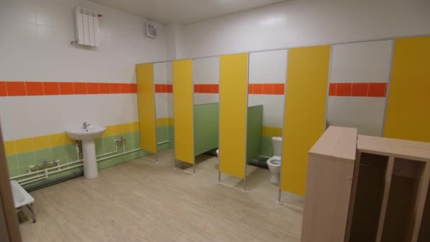 Public toilet with colorful toilet cabins showers and sinks — Stock Video
