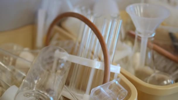 Various lab glassware and tools in plastic boxes on table — Stok video