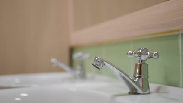 Shiny metal faucet with lever on sink in public restroom — Vídeo de Stock