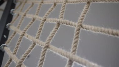 Rope net on trainer for climbing in light hallway of gym