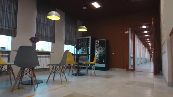 Mesas con sillas cerca de máquinas expendedoras y de café en la cafetería — Vídeo de stock