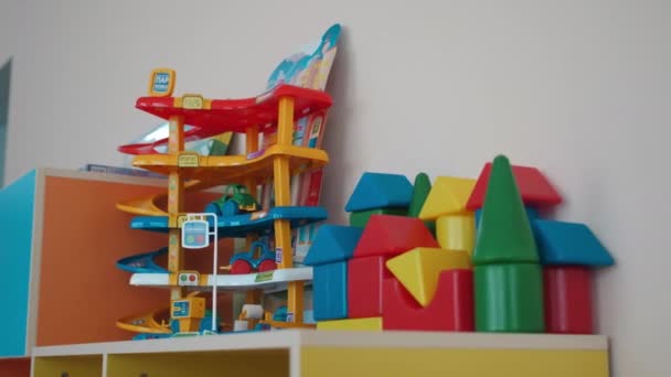 Toy parking lot and constructor on cabinet in kindergarten — Stockvideo
