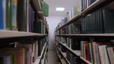 Narrow passway between racks with books in public library