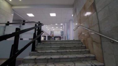 Motion above marble steps to large empty decorated hallway