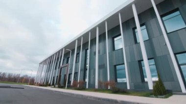 Corporate building with white poles and arch on street