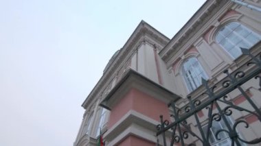 Old building with elegant ornate facade and metal fence