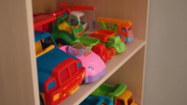 Collection of toy cars on wooden rack in kindergarten room