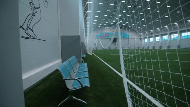Empty chairs near indoor football field at sports complex — Stockvideo