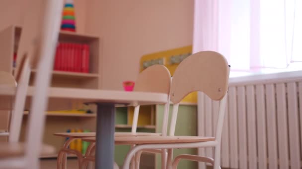 Ξύλινο τραπέζι με μικρές καρέκλες στην τάξη του νηπιαγωγείου — Αρχείο Βίντεο