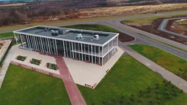 Stylish building with paved ground against autumn forest