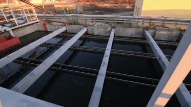 Güneş batarken atık su arıtma istasyonunda su dolu havzalar.