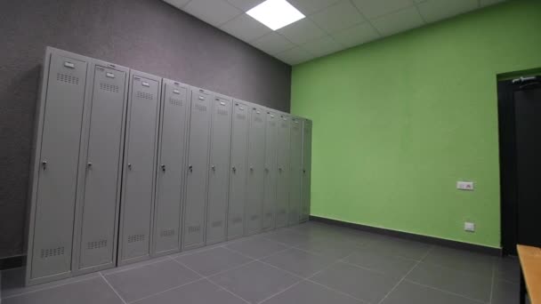 Cabinets and bench in empty locker room at sports complex — Stock Video