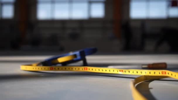 Yellow tape measure on concrete floor at construction site — Stock Video