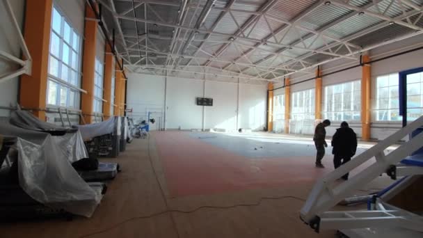 Munkavállalók csoportja ellenőrzi padló dolgozik tágas tornaterem — Stock videók