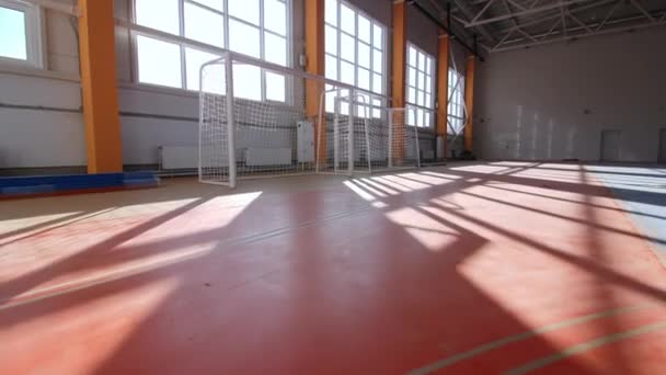 Puerta de fútbol se encuentra junto a grandes ventanas en el gimnasio renovado — Vídeos de Stock