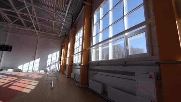 Mozgás a nagy ablakok és a futball kapu mellett az árnyékos edzőteremben — Stock videók