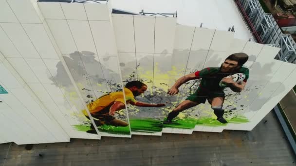 Falfestmény focimeccsjelenettel a stadion homlokzatán — Stock videók