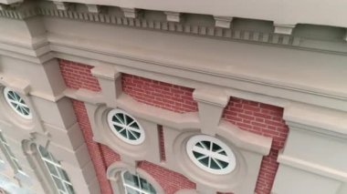 Yuvarlak pencereli kırmızı tuğla bina ve klasik süsleme