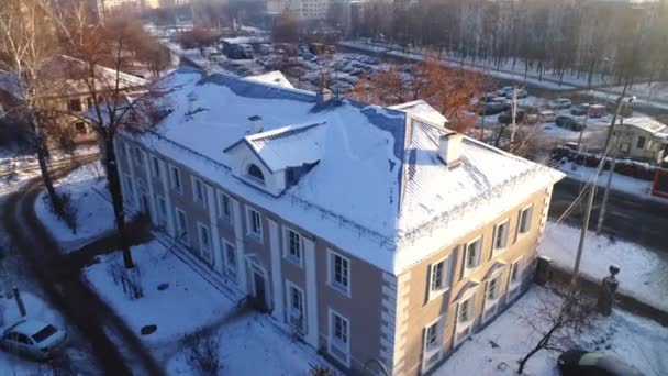 Gebäude mit schneebedecktem Dach auf der Stadtstraße bei Sonnenuntergang — Stockvideo