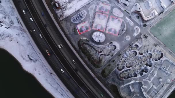 在雪地的河岸上，高速公路上靠近体育场的地方有车 — 图库视频影像