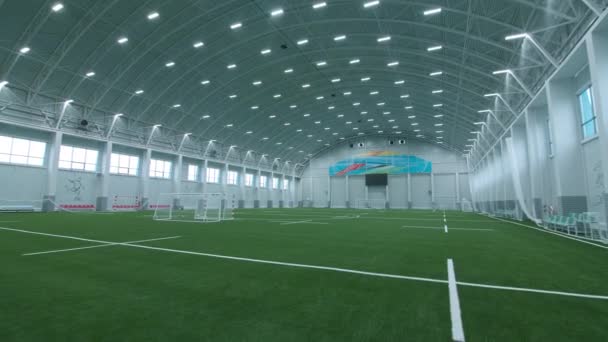 スポーツ複合施設で大規模な屋内サッカーアリーナに沿って運動 — ストック動画