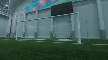Dijital ekranın altındaki kapalı futbol sahasındaki boş kapı