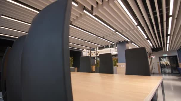 Elegante mesa vacía y sillas en el pasillo de coworking — Vídeo de stock