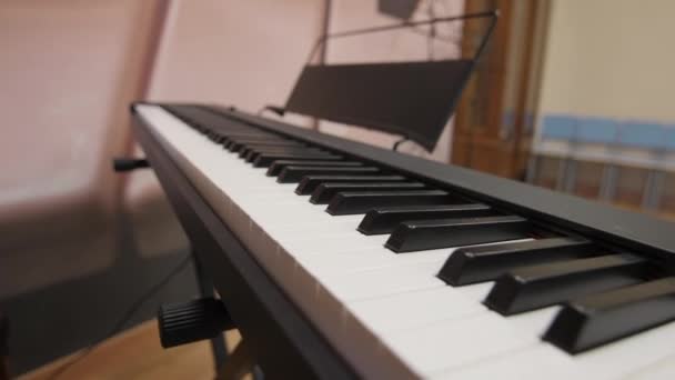 Piano digital teclas en blanco y negro y soporte de música vacío — Vídeo de stock