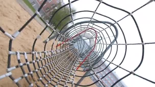 Seilnetztunnel im Labyrinth auf sandigem Spielplatz im Stadtpark — Stockvideo