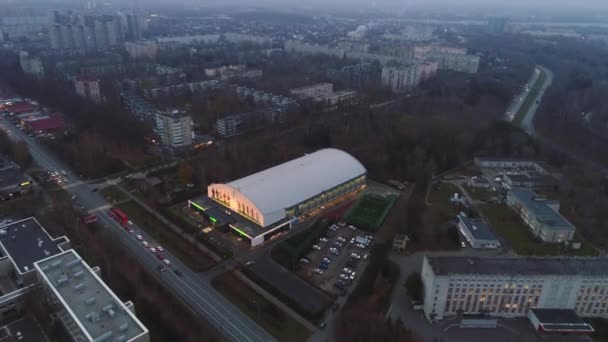 Oświetlona hala sportowa budynku i parku w mieście wieczorem — Wideo stockowe