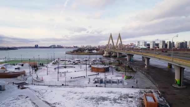 Snowy park per attività sportive sulla riva del fiume vicino al ponte — Video Stock