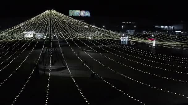 Eleganta älva ljus hänga över torget nära köpcentrum — Stockvideo