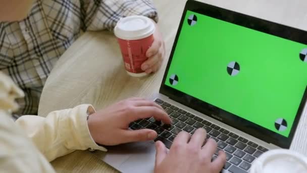L'uomo lavora su computer portatile con schermo cromakey da amico in caffè — Video Stock