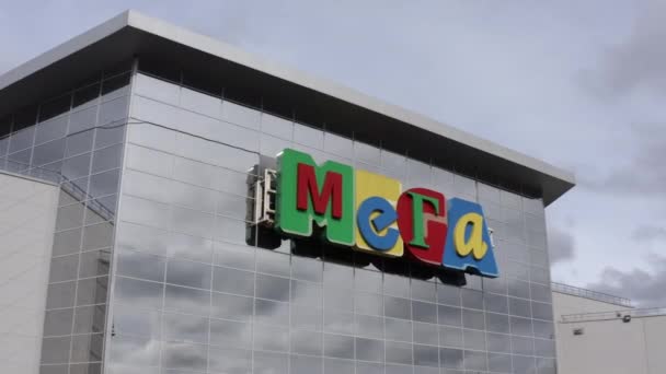 Jasne logo centrum handlowego Mega na szklanej fasadzie budynku — Wideo stockowe