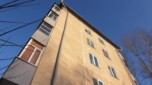 Antiguo edificio de apartamentos de panel con caño de agua bajo el cielo despejado — Vídeos de Stock