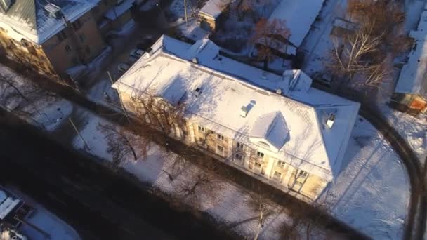 Oud appartementencomplex met besneeuwd glooiend dak op straat — Stockvideo