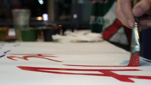 男人用红色油漆在海报上写文字来支持团队 — 图库视频影像