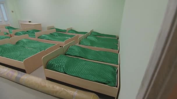 Paturi mici cu pături verzi în dormitor de grădiniță — Videoclip de stoc