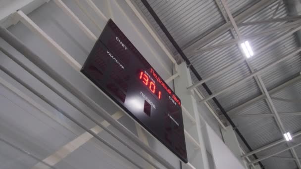 Πίνακας αποτελεσμάτων με ψηφιακό ρολόι κρέμεται στον τοίχο στο γήπεδο σπορ — Αρχείο Βίντεο
