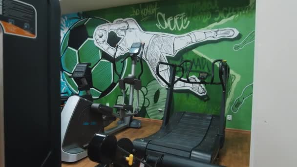 Spor salonunda futbol dekoru olan duvardan duvara eğitim makineleri — Stok video