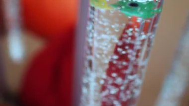 Hava kabarcıkları ve renkli plastik balıklar tüpte suyla