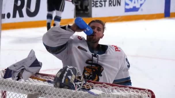 Portero de hockey en uniforme protector bebe agua en el descanso — Vídeos de Stock