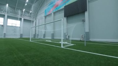 Kapı spor sahasındaki boş yeşil futbol sahasında duruyor.