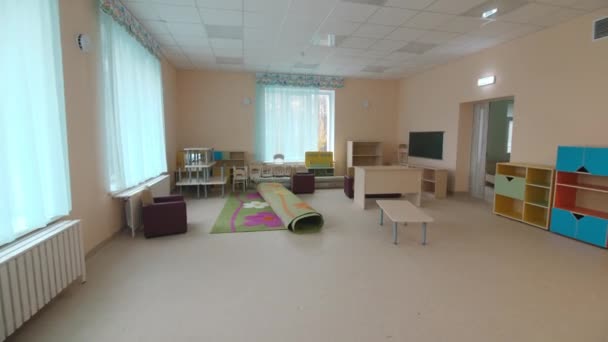 Новая игровая комната с мебелью и ковром в детском саду — стоковое видео