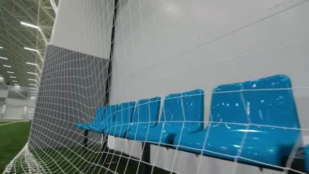 Стулья и защитная сетка возле большого футбольного поля — стоковое видео