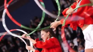 Atletik kadınlar hokey takımını desteklemek için yüzüklerle gösteri yapıyorlar.