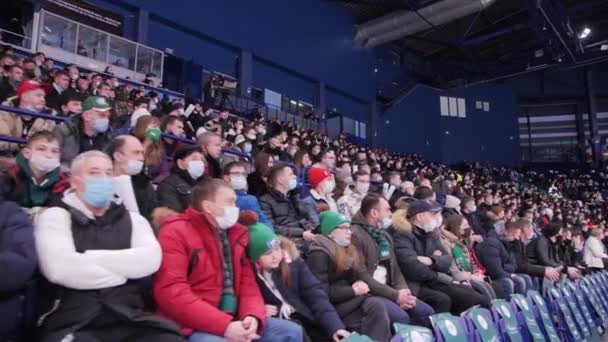 Público con máscaras protectoras relojes partido de hockey — Vídeos de Stock