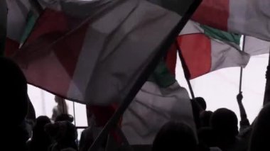 Spor taraftarları renkli bayraklar sallayarak hokey maçından zevk alıyorlar