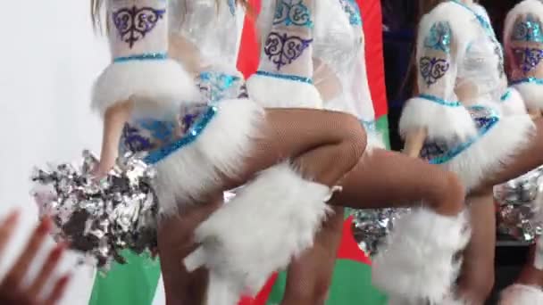 Cheerleaders with silver pompoms dance at hockey game — Stock Video