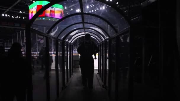 Une équipe de juges arrive sur une patinoire à travers un tunnel à voûte sombre — Video